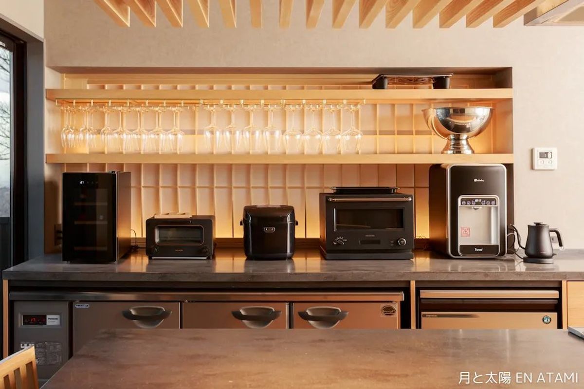 A tidy kitchen interior. Create a dining table using cooking utensils and dishes.