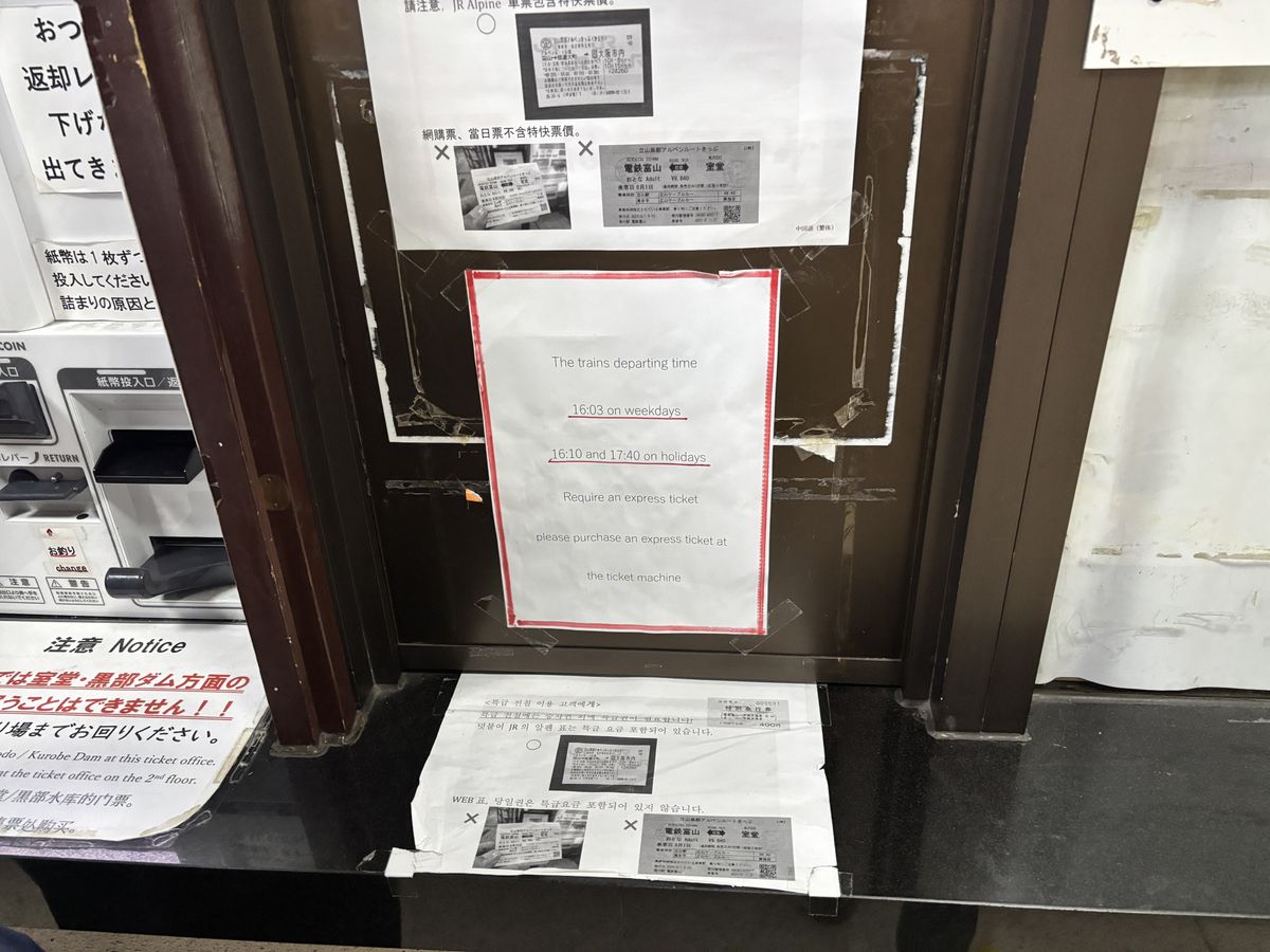 Multilingual ticket-buying instructions in English, Chinese, and Korean posted on the ticket machines at Tateyama Station, with limited express ticket notices (Toyama Chiho Railway)