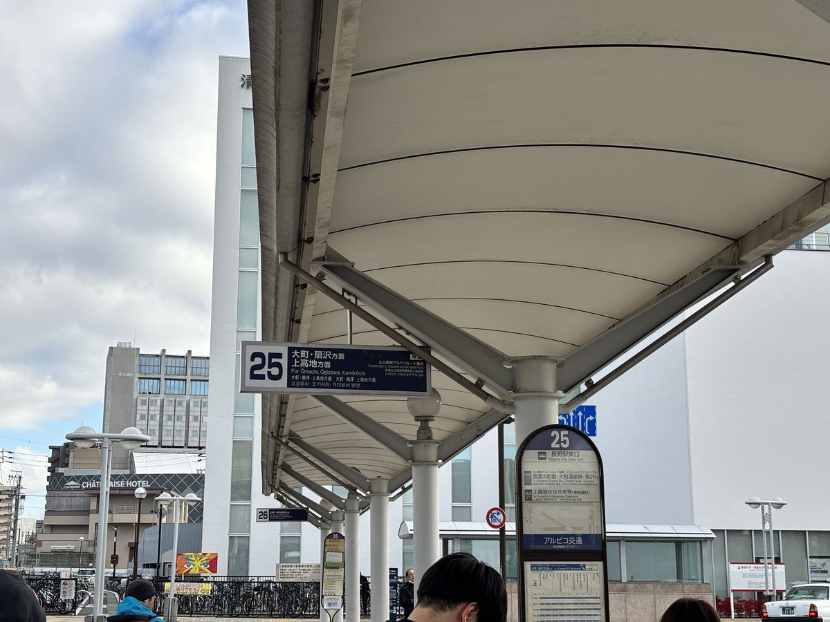 Platform 25 sign under the station bus shelter, marking departures for Omachi and Ogizawa Station and for Kamikochi