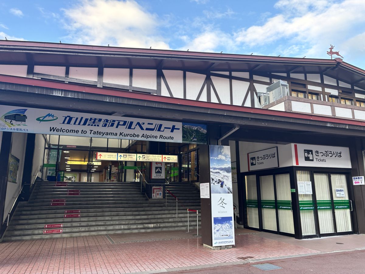 Ticket windows and information boards lining the entrance hall of a Tateyama Kurobe Alpine Route station